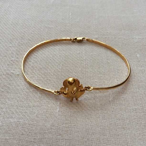 Delicate, 18k gold Ganesh bracelet. Ganesh is [1/2in x 1/2in] Bracelet is 2 1/2in across when clasped.
